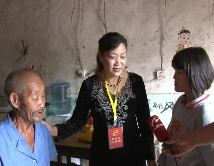 杨玉琴在孤儿何小雪家中，与80多岁的爷爷交谈